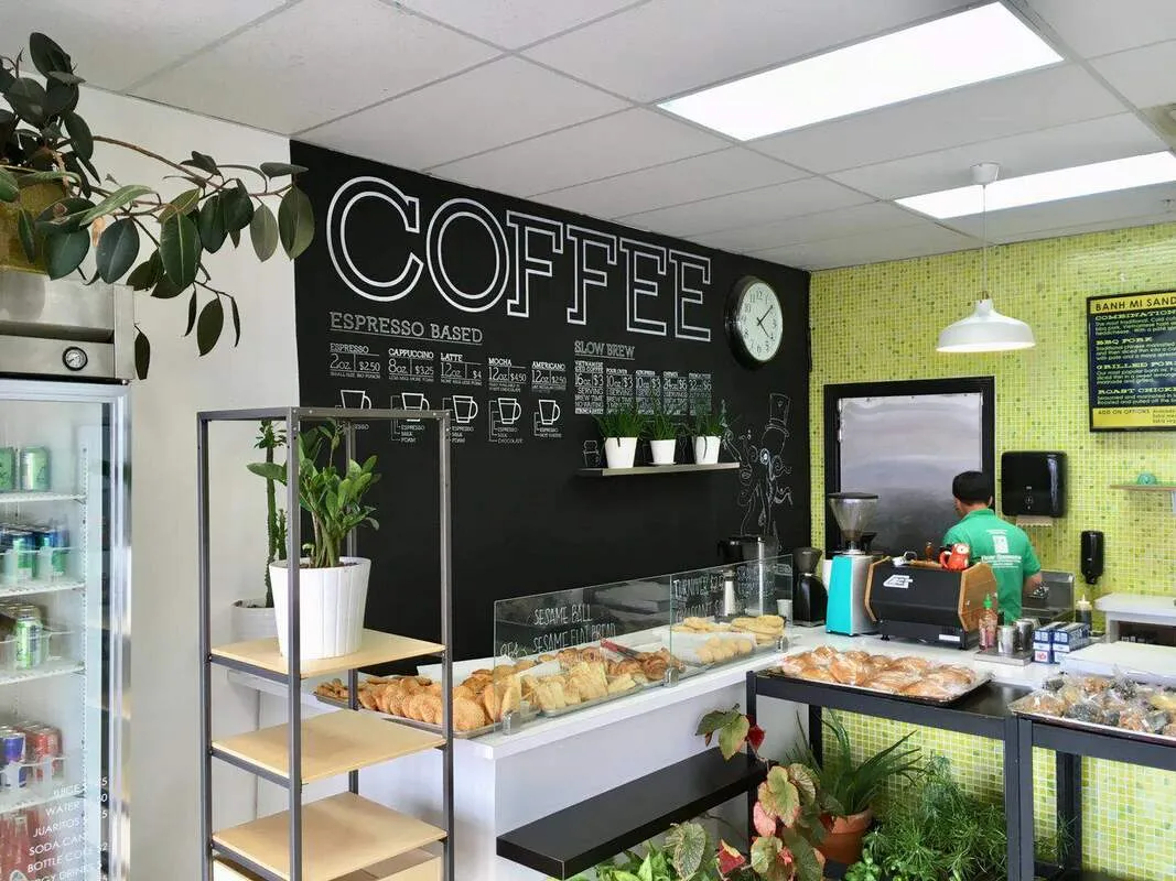 Coffee menu chalkboard above a case of fresh-baked pastries